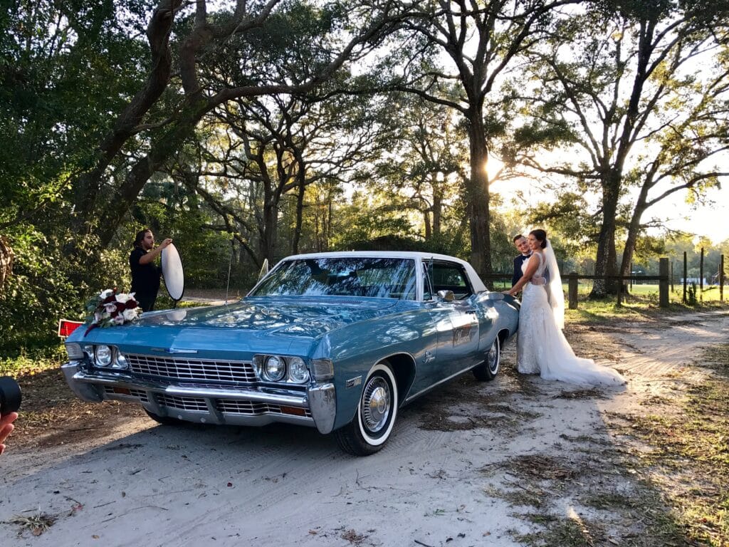 Bride and groom take photos with the 1968 Impala.