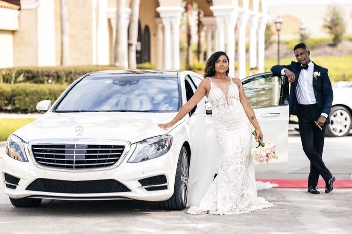 Bride and groom posing with the Mercedes S550.
