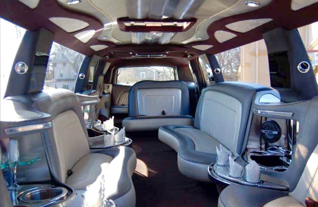 The interior of the Cadillac Escalade limo features leather seating, TVS, cupholders, and more.