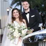 Bride and groom smiling next to the Rolls Royce Ghost