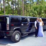 Bride and groom pose next to the Black Hummer SUV limo.