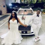 Bride and groom hold hands in from of the Rolls Royce Ghost