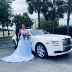 Bride and groom pose next to the Rolls Royce Ghost.