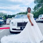 A bride poses with her wedding limo, the Rolls Royce Ghost.