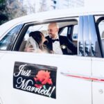 Bride and groom sit inside the Rolls Royce Ghost with custom Exotic Limo "just married" sign.