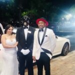 Exotic Limo chauffer poses with bride and groom.
