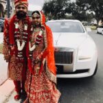 Indian bride and groom pose in front of the Rolls Royce Ghost