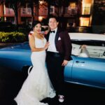 A bride and groom poses with Exotic Limo's classic 1968 Chevy Impala.