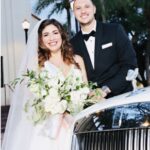 Bride and groom pose by their wedding car from Exotic Limo Orlando, the Rolls Royce Ghost.