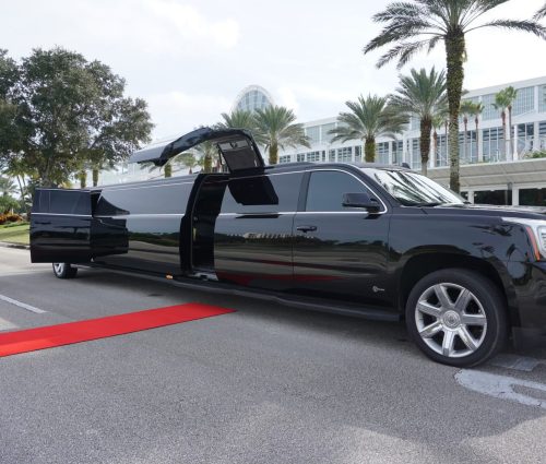 Black Cadillac Escalade Limo with doors open and red carpet.