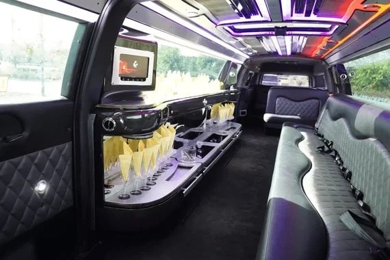Bar and champagne flutes set up in the black Escalade limo interior.