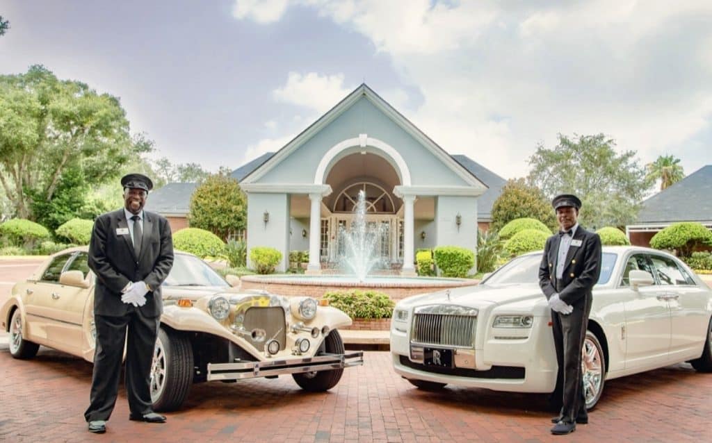 2 chauffeurs standing with their luxury vehicles for a grand wedding send off